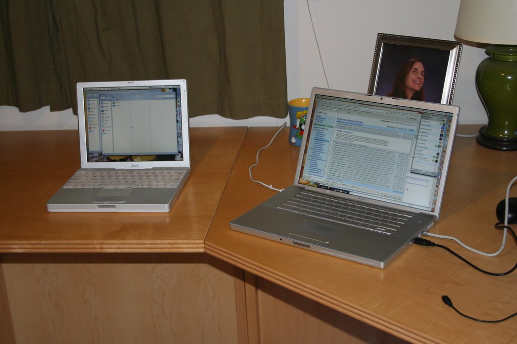 Laptop and notebook on a desk prepared for email and web project planning.